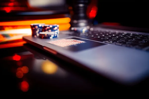 A woman smiling while playing online games on her laptop, surrounded by neon casino elements, showcasing MARAKUMI’s diverse game collection.
