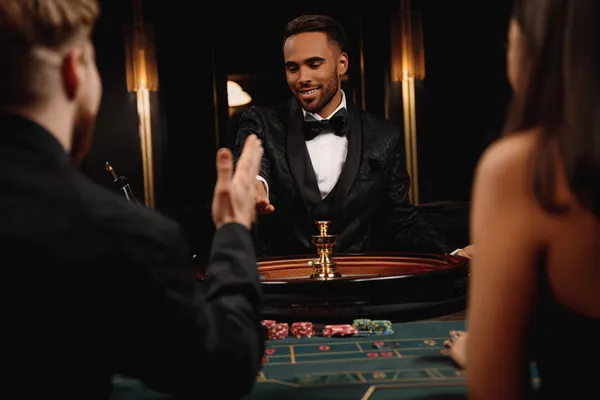 A confident dealer surrounded by casino chips inviting players to access their MARAKUMI account, reflecting quick and easy login options.